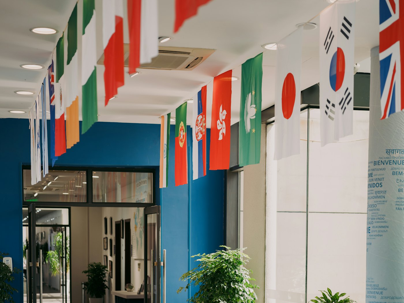 Flags of many nations hanging in a bright hall