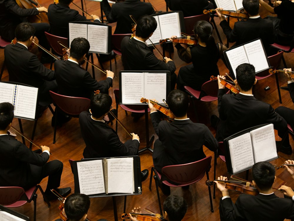 A young orchestra seen from above, players seated at their music stands