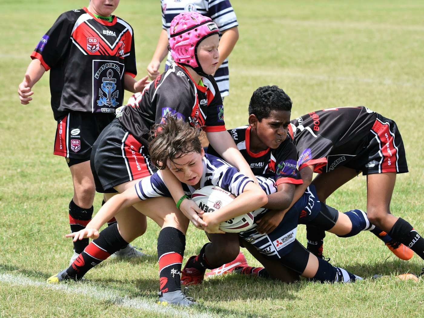 Young rugby players driving forward with the ball in a match